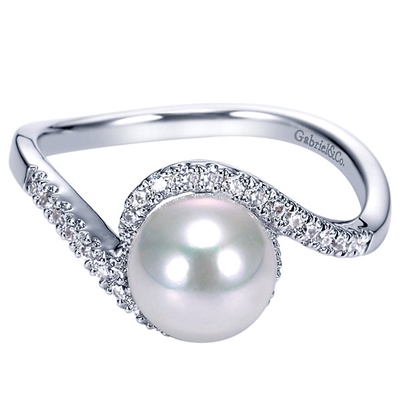 One pearl sits in the center of round diamond halo swirl in 14k white gold pearl and diamond ring.
