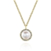 A cultured pearl sits in the center f this 14k yellow gold diamond and pearl necklace.