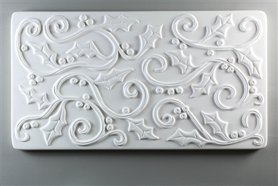 A long rectangular tile made of white ceramic. The carved texture is filled with curving lines with holly leaves and small round holly berries attached at various points.