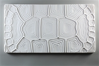 A long rectangular tile made of white ceramic. The carved texture has the appearance of a tortoise shell that has been flattened to occupy the space. The shell design takes up the entire tile.