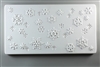 A long rectangular tile made of white ceramic. The carved texture has different sizes and shapes of snowflakes scattered around it. Some are carved into the texture while others stand out.