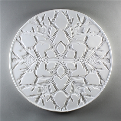 A circular tile made of white ceramic. The carved texture is occupied entirely by the design of a single snowflake with a thin border around the outside. The snowflake is intricate with many branches and lines in its pattern.