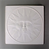 A large square tile made of white ceramic. The carved texture has a sun with a human face in the center. The sun has rays that are pointed and rays that are curved and is surrounded by additional lines radiating outward to the circle enclosing it all.