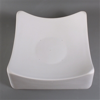 A square white ceramic mold for fusing glass on a grey background. Each corner of the square curves slightly upwards. There are five small vent holes spaced around the center.