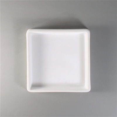 A square white ceramic mold for fusing glass on a grey background. The mold has a narrow wall around its edges and the remainder is completely flat.