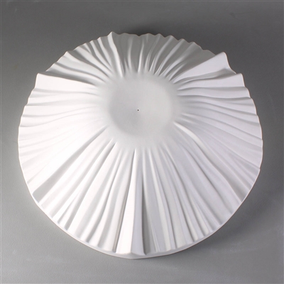 A circular white ceramic mold for fusing glass on a grey background. It is raised into a dome shape, with a smaller flat circle at the very center. There are raised lines radiating outwards and downwards from this flat center.