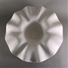 A tall circular white ceramic mold for fusing glass on a grey background. The very center has been carved down into a flat circle, and the edges raise up into a wide ruffled border around the entire circle, creating a deep flower-like shape.
