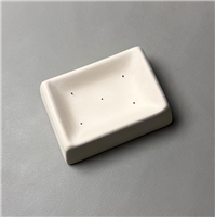 A rectangular white ceramic mold for fusing glass on a grey background. The edge of each side curves slightly upwards, creating a smaller, shallower rectangle in the center with five tiny, evenly spaced vent holes in its center.
