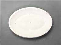An oval shaped ceramic mold for slumping glass shown on a gray background. The mold has a thin rim around the outside, and slopes gently inward to a smaller flat oval bottom. There are five small vent holes in the flat portion.