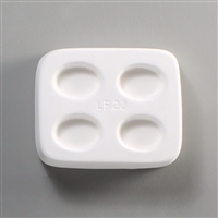 A rectangular white ceramic mold for fusing hot glass on a grey background. Four identical ovals have been carved into it with equal space between them. LF22 is carved in the middle of the mold.