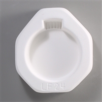 An octagonal white ceramic mold for fusing hot glass on a grey background. A plain circular Christmas ornament has been carved into it. LF24 is carved onto the mold below the ornament.