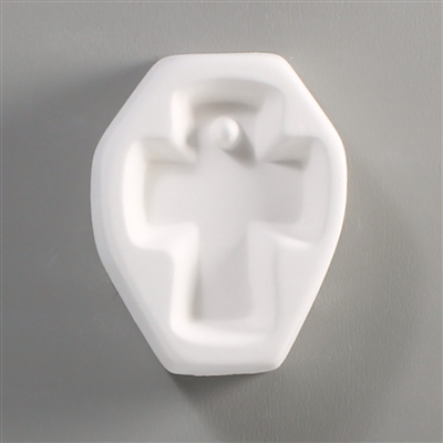 A white ceramic mold for fusing hot glass on a grey background. A simple cross with slightly rounded edges has been carved into it. There is a square post towards the crossâ€™ top allowing for the resulting glass to be strung as jewelry.