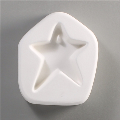 A pentagonal white ceramic mold for fusing hot glass on a grey background. A simple five-pointed star with slightly asymmetrical bottom legs has been carved into it. There is a post towards the top of the star allowing for the resulting glass to be strung