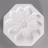 An octagonal, white ceramic mold for fusing hot glass on a grey background. A large, flat, detailed daisy flower with ten petals has been carved into it.