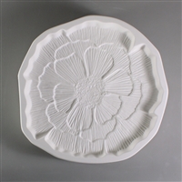 A circular, white ceramic mold for fusing hot glass on a grey background. An intricately detailed flat poppy flower has been carved into it. The flower takes up most of the mold, but there is a small border of empty space around it.