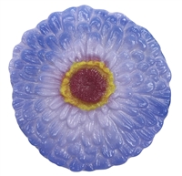A flat fused glass zinnia flower on a transparent background. The petals are dark lilac on the outside fading into lavender towards the center, with a small bit of magenta around the center itself. The center has a ring of yellow around a dark red middle