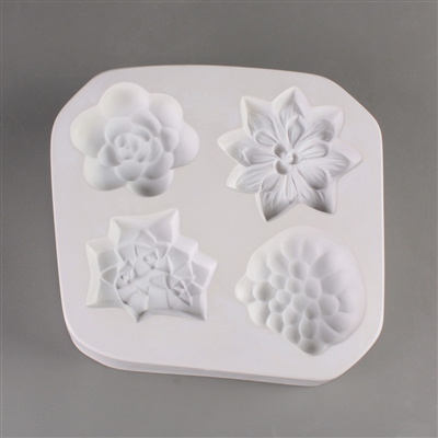 A square white ceramic mold for fusing hot glass on a grey background. Four detailed succulents have been carved into it. Each succulent has a different design similar to that of a real species, but all are similarly sized.