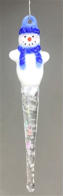 A fused glass snowman ornament hanging in front of a gray background. The snowman has a blue knit hat and scarf and an opaque white body that tapers into a clear iridescent icicle. The snowman has an orange nose and pink cheeks.