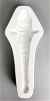 A long white ceramic mold for fusing hot glass on a grey background. A penguin in a knit cap and scarf with outstretched wings and a body tapering into an icicle has been carved into it. The hat has a post in it allowing for hanging after firing.