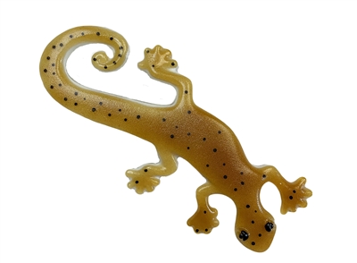 A fused glass lizard on a white background. The lizard is a dark amber color with large black eyes. Small round dots of black are speckled throughout its body and tail.