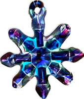 A fused glass snowflake ornament hanging in front of a transparent background. The ornament has a faceted design filled with different bright blues and purples. The colors are all transparent, allowing light to shine through.