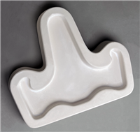 A T-shaped white ceramic mold for fusing hot glass on a grey background. A simple flat easel shape with a long back part and two slightly curved arms on either side has been carved into it.