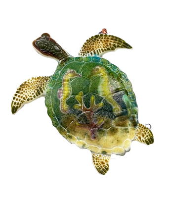 A detailed sea turtle made from fused glass on a transparent background. Its shell has been filled with smaller glass seahorses and coral, and colored to look like a blue-green ocean with pale sand at the bottom.