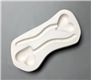 A vaguely rectangular white ceramic mold for fusing glass on a grey background. Two garden stakes have been carved into it facing opposite directions. Each has a thin, curving stem, and each is topped with a slightly off center heart.