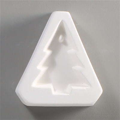A triangular white ceramic mold for fusing hot glass on a grey background. A simple Christmas tree shape has been carved into it. There is a post towards the top of the tree allowing for the resulting glass to be strung as jewelry or hung up.