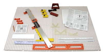 A photo of the Morton Glass System on a white background. The system includes a large plastic grid, several straightedges, a set of paper instructions, and a variety of implements for accurately cutting glass.