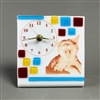 A rectangular piece of fused glass that has been bent to allow it to stand. It has a clock face printed on it as well as the image of a yawning cat. The clock has working hardware. The base glass is white, with additional red, yellow, and blue squares.