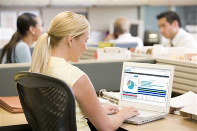 Woman on laptop using AION scheduling software services in an office