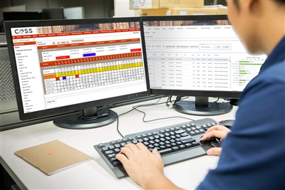 Man at desk with stationary computer viewing Visual Computer Solutions COSS software service