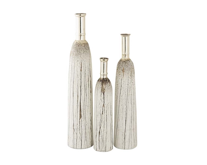 The Coco Vases include three tall, narrow glass vases with a vertical etched line pattern. Each vase features a drippy, speckled brushstroke pattern in white and brown which moves vertically down the vase from the neck, which has a metal finish.