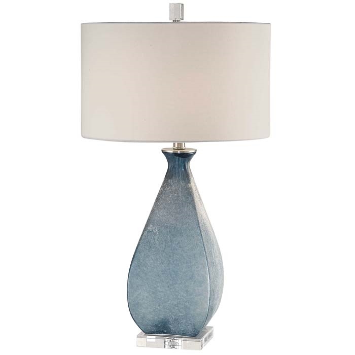 Atlantica Modern Lamp. Deep ocean blue glass with an acid etched texture, accented with brushed nickel plated details and a thick crystal foot. The round hardback drum shade is a white linen fabric.