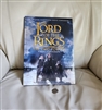 Front cover of The Two Towers Visual Companion hardcover book next to a coin for scale reference