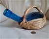 Round blue glass wine ebottlein grass woven basket