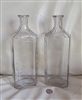 Tall clear glass apothecary embossed bottles