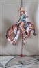 Rodeo cowboy on a backing Bronco wooden ornament