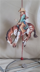 Rodeo cowboy on a backing Bronco wooden ornament
