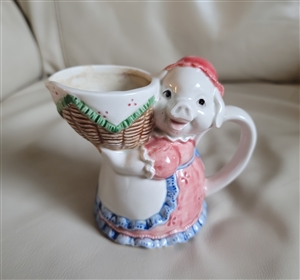 Preowned vintage Otagiri porcelain lady pig holding basketweave creamer figurine front view
