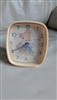 The front view shows a square 1992 Precious Moments Westclox alarm clock with a pale pink frame and a girl hugging a goose on the dial next to the text Waddle I Do Without You