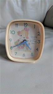 The front view shows a square 1992 Precious Moments Westclox alarm clock with a pale pink frame and a girl hugging a goose on the dial next to the text Waddle I Do Without You