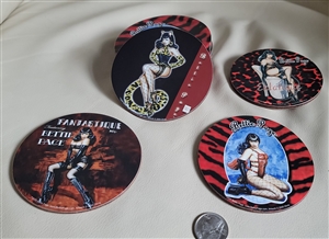 Four circular Bettie Page pinup coasters with unique images displayed next to a metal tin that features two different images on the front and back
