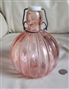 Pink glass bulbous bottle with wire closure