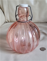 Pink glass bulbous bottle with wire closure