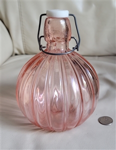 Pink glass bulbous bottle with wire closure