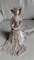 Victorian style porcelain doll in a tassel dress
