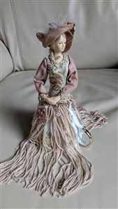 Victorian style porcelain doll in a tassel dress
