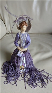 Victorian style porcelain doll with tassle dress